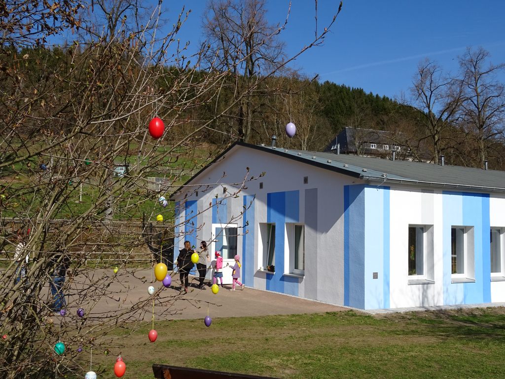 Das Kindergartengebäude mit verschiedenen blauen vertikalen Streifen auf weißem Grund