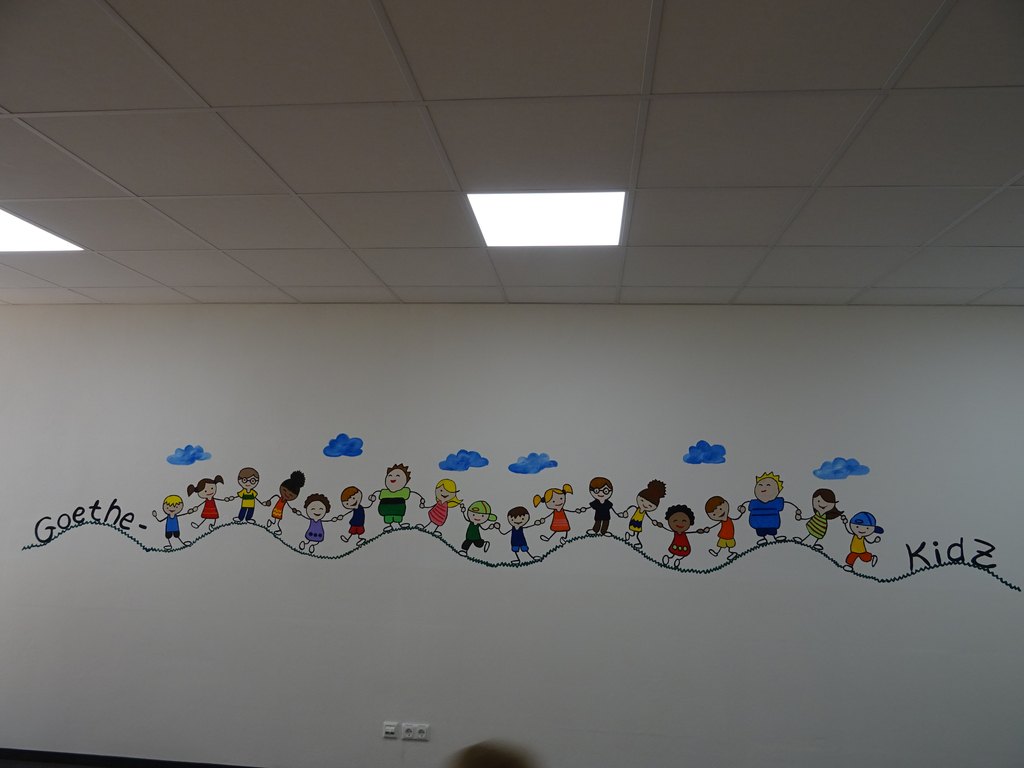 Wandgestaltung mit Kindern als Strichzeichnung bunt und einer Wellenlinie darunter