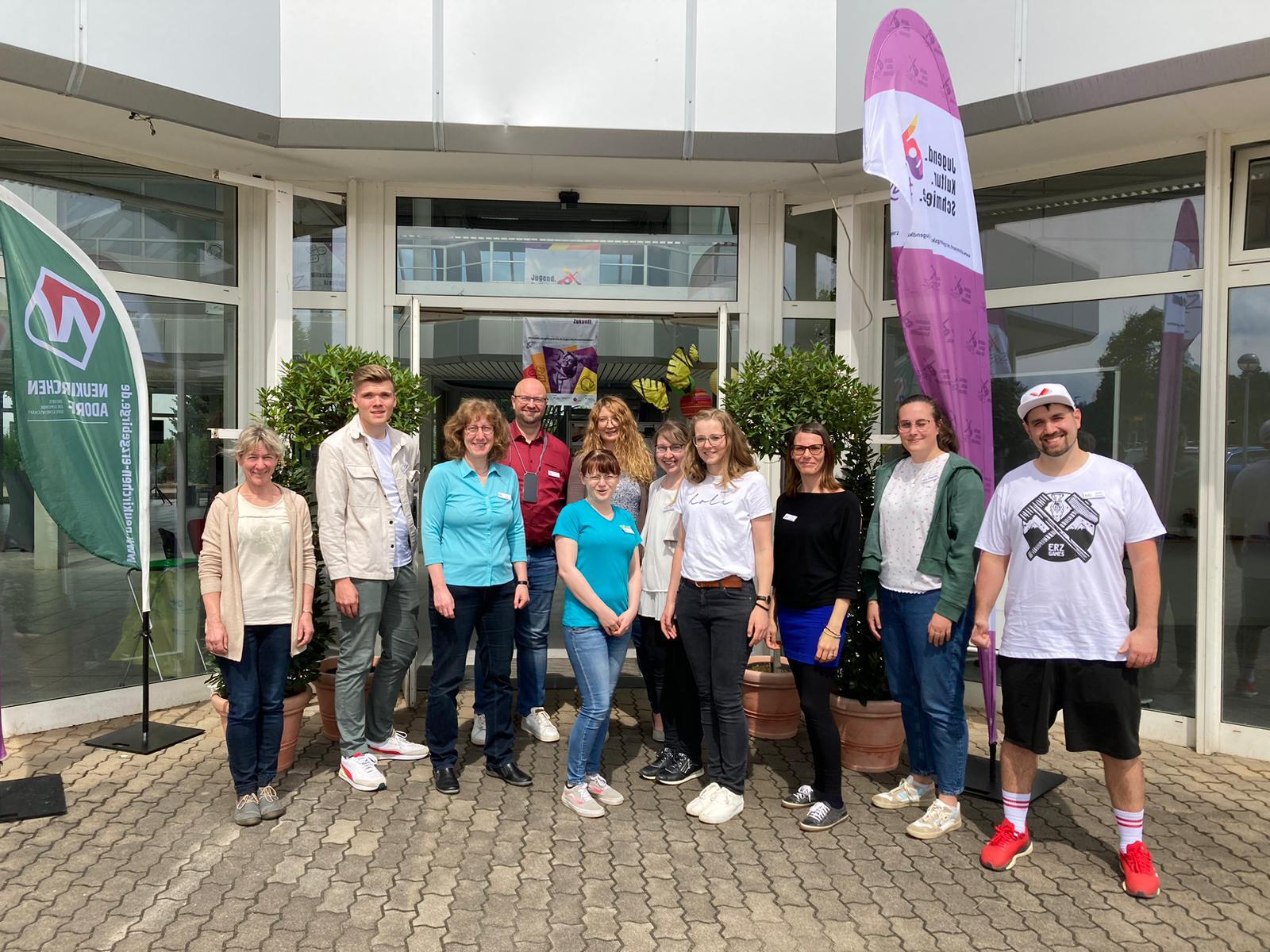 Das Bild zeigt eine Menschengruppe vor einem Hauseingang.